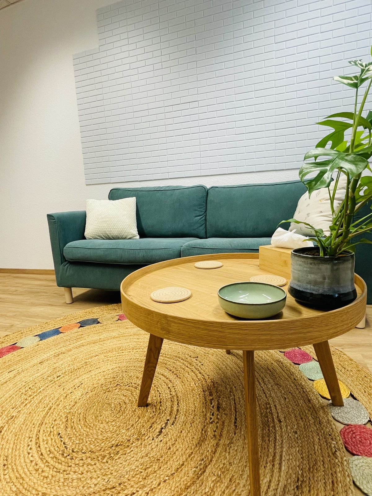 Sitzecke mit Sofa, Holztisch und Pflanze
